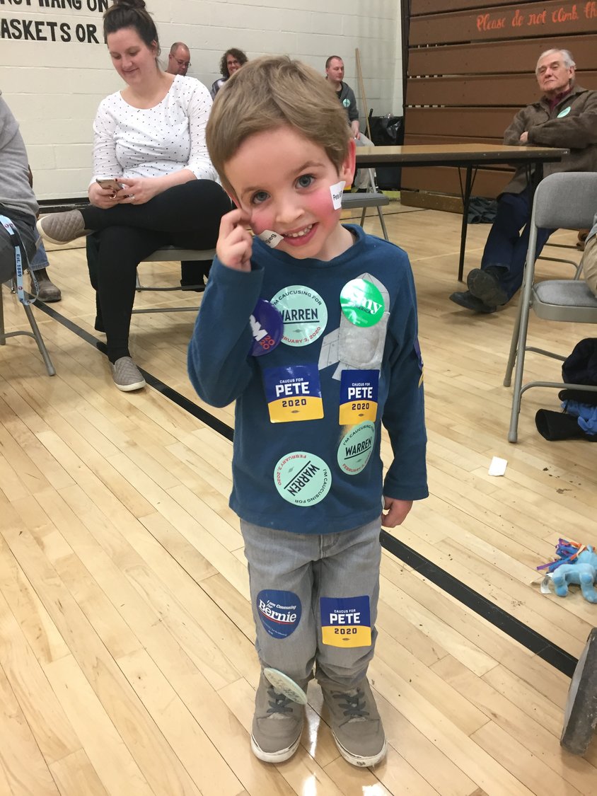 Lyndon Scott, 4, shows his support of all the candidates at the Democratic caucus in Kalona.